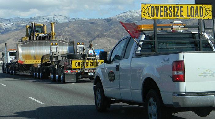 pilot escort truck behind an oversized truck load